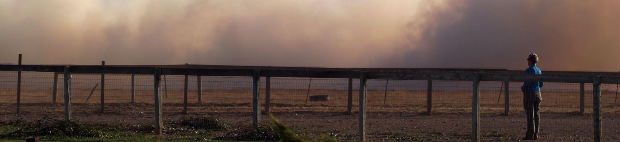 fence line with smoke in background