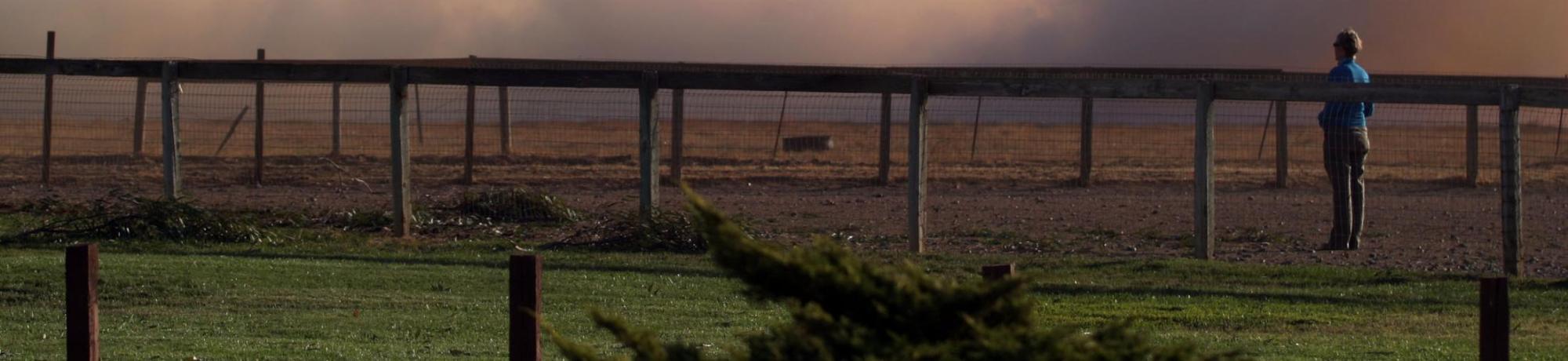 fence line with smoke in background